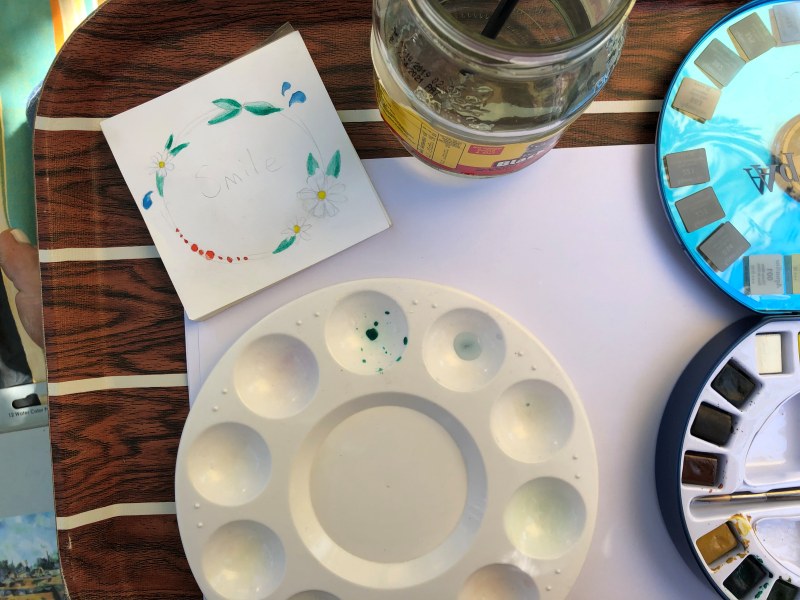 A collection of art materials as some creates a watercolour doodle. 